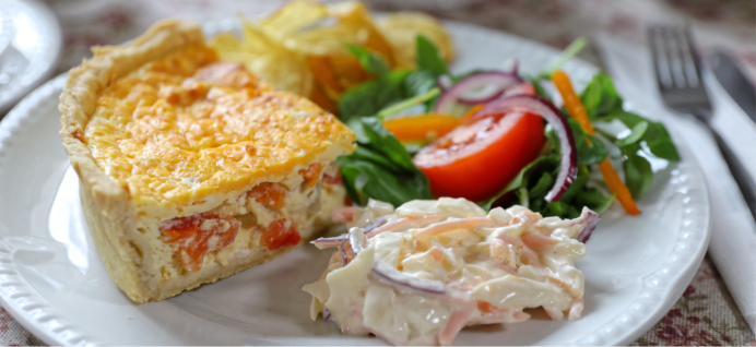 A slice of quiche and a salad on a place
